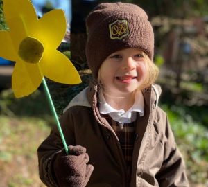 girl in uniform holding daffodil